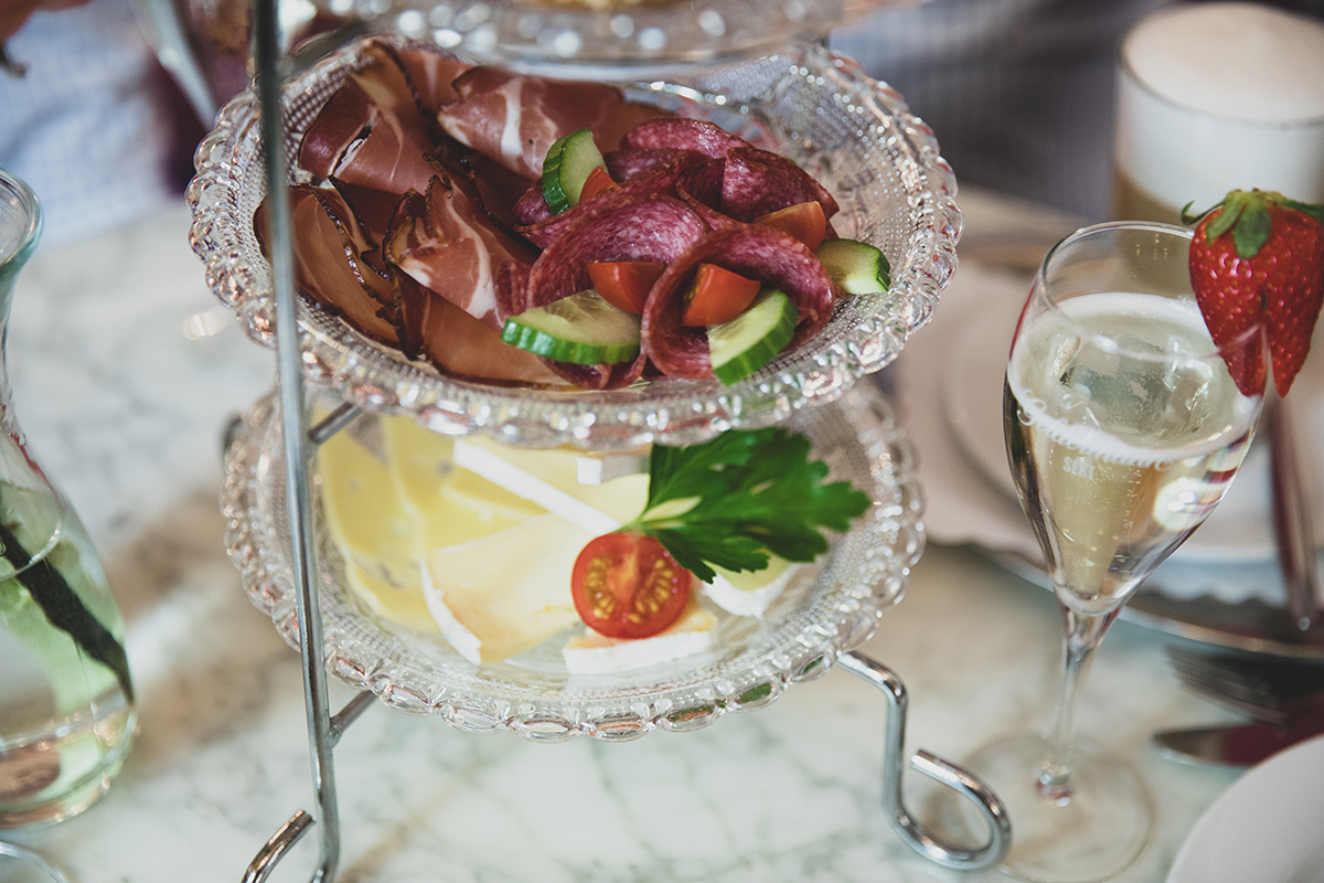 Das Bild zeigt eine Käse- und Wurstplatte angerichtet in einem dekorativem Ständer