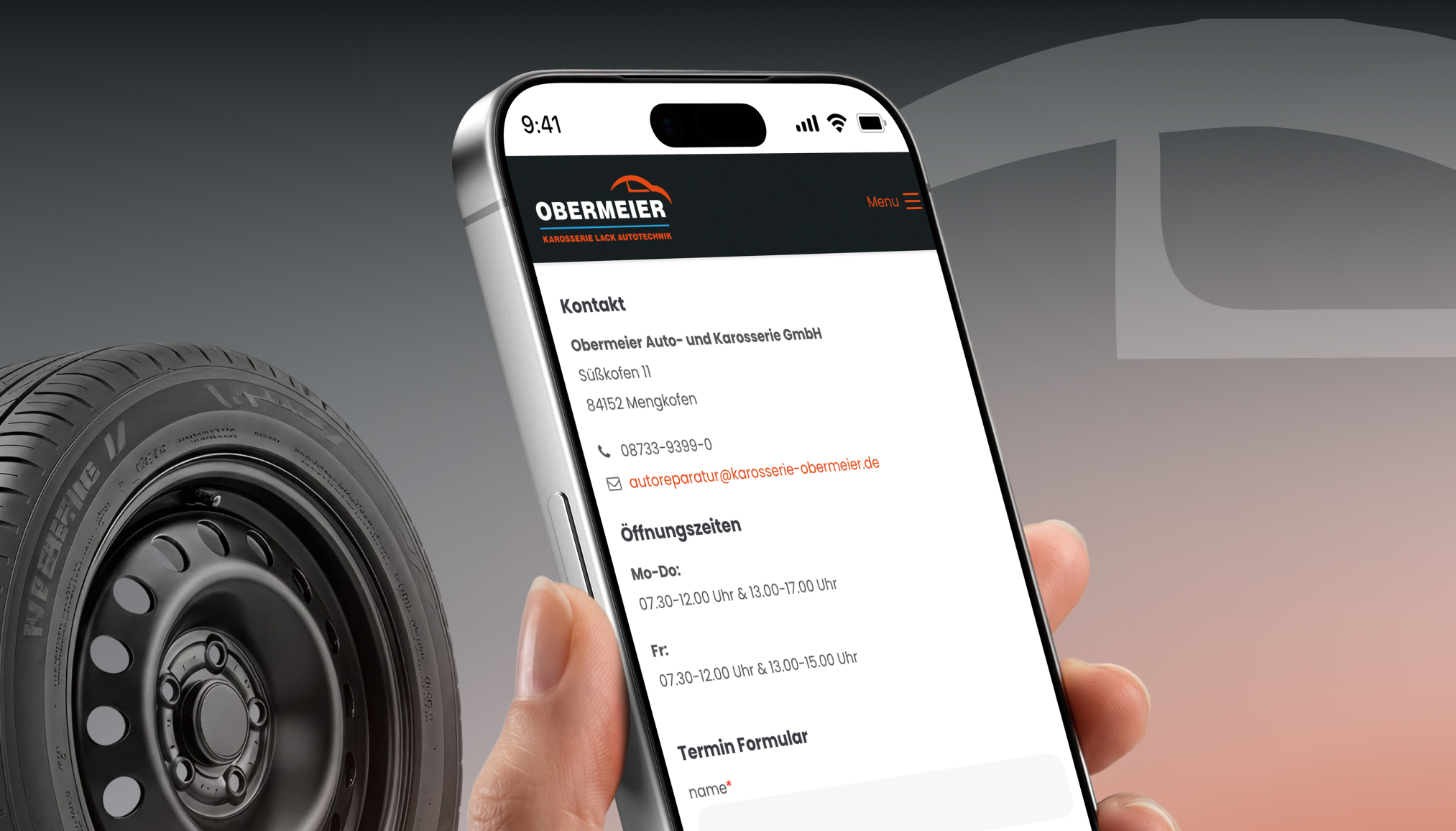 Eine Person hält ein Smartphone mit der Website der Obermeier Werbeagentur in Landshut, inklusive Kontaktdaten.